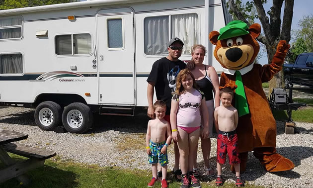 A family poses together with a Yogi Bear mascot.