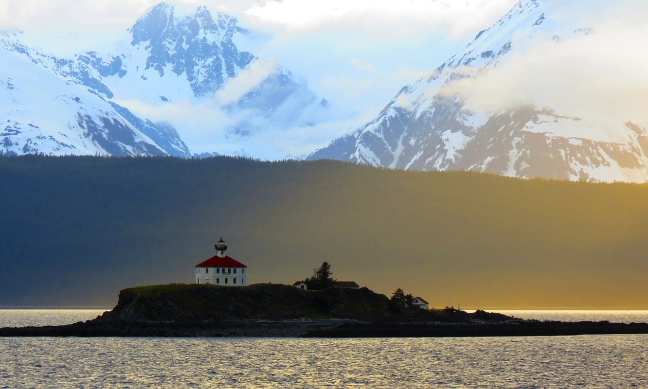 lighthouse with mountains in the background 