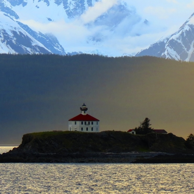 lighthouse with mountains in the background 