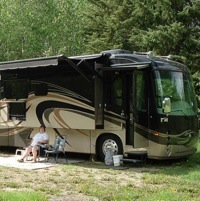 Grace Christian sitting outside their 2012 Integra Aspire Class A Diesel Pusher with four slides.