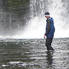 people standing beside a waterfall