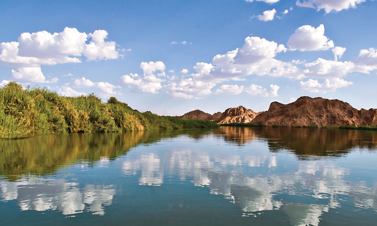 Horizon shot of water and blue sky with mountains in the background - Yuma, Arizona