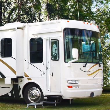 A large motorhome parked in a treed spot