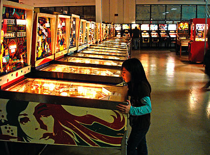 Girl playing on a pinball machine