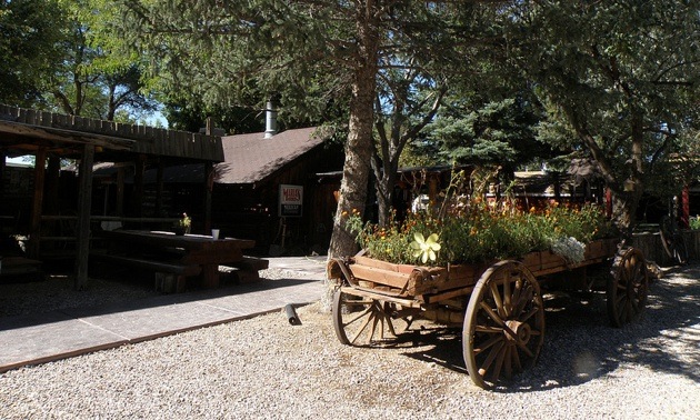 The entrance of Beaver Canyon Campground has an old wooden wagon full of flowers.