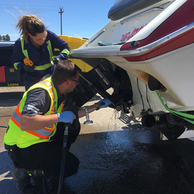 An employee inspects a boat for invasive plants and mussels. 