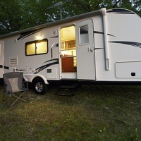 RV trailer parked near trees with no connections.