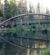 A photo of a bridge and its reflection in the water.