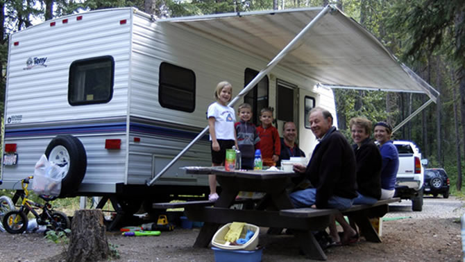 Picture of family camping beside RV. 
