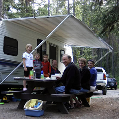 Picture of family camping beside RV. 