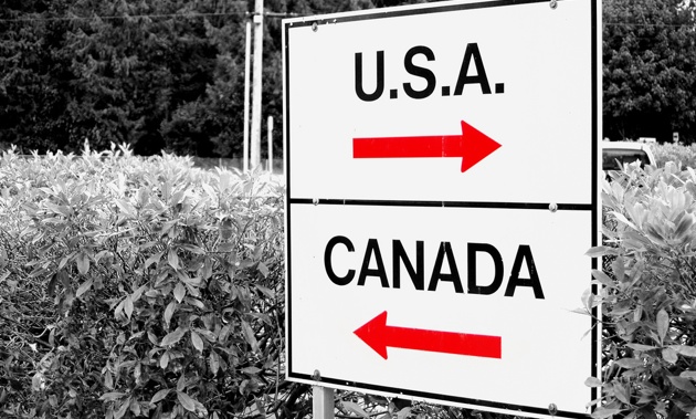 A sign giving at a Canada/USA border crossing.