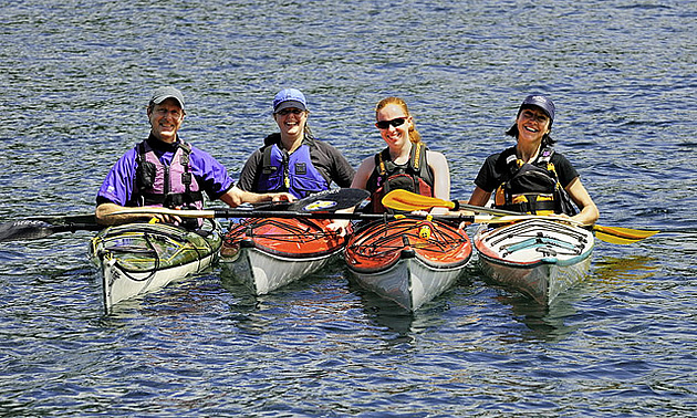 people sitting in kayaks