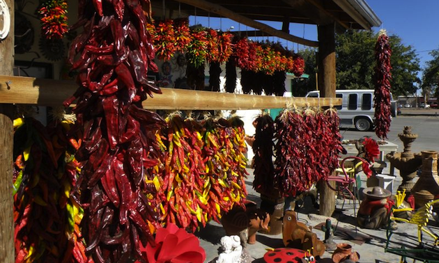 Decorative strings of chiles hanging in an outdoor market.