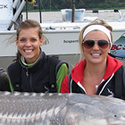 women holding onto a large fish