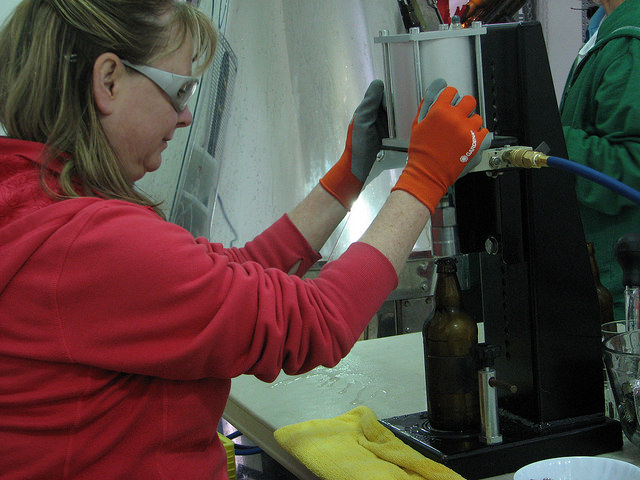 Barb Kelly caps each bottle at Left Field Cider Co.