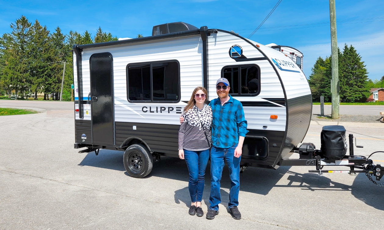 Sara and her husband standing in front of their new Clipper RV