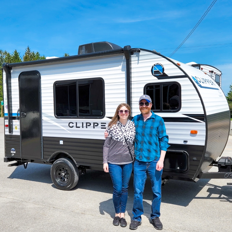 Sara and her husband standing in front of their new Clipper RV