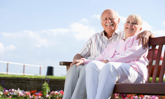 Older couple sitting on a bench in a garden