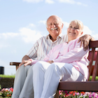 Older couple sitting on a bench in a garden