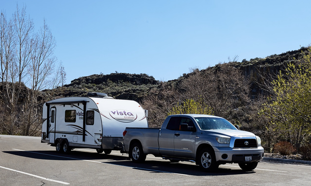 Truck and camper with small mountains in the background