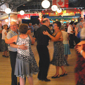 Dozens of couples dancing on the hardwood floor of Danceland.  