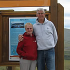 Husband and wife standing in front of an Arctic Circle sign