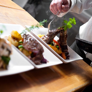 The chef putting the finishing touches on three plates at the Angler's Dining Room. 