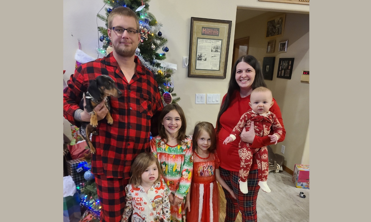 A family of six dressed in matching red plaid Christmas outfits
