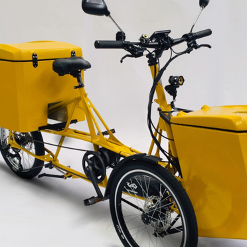 yellow e-trike with cargo baskets in front and back