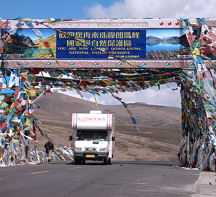 The sign marking the 4,000 metre high entrance to the Qomolangma Nature Preserve is festooned with prayer flags.