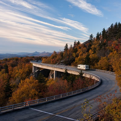 Picture of RV travelling along a winding highway in the autumn. 