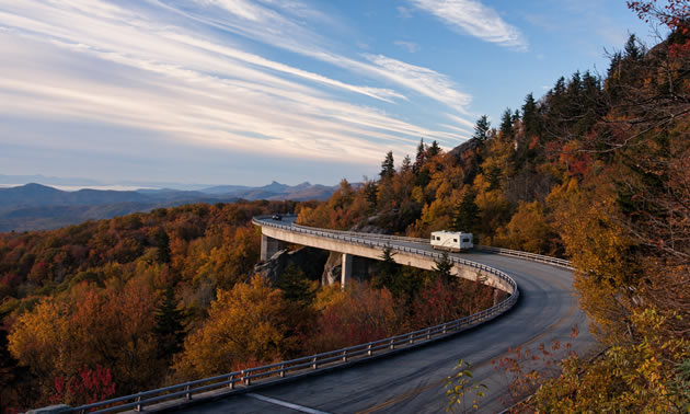 Picture of RV travelling along a winding highway in the autumn. 