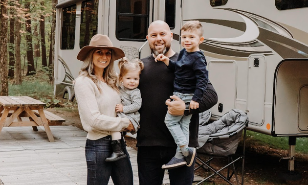 A lady and man with their two children in front of their RV