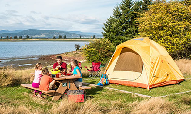 Family camping by lakeshore. 