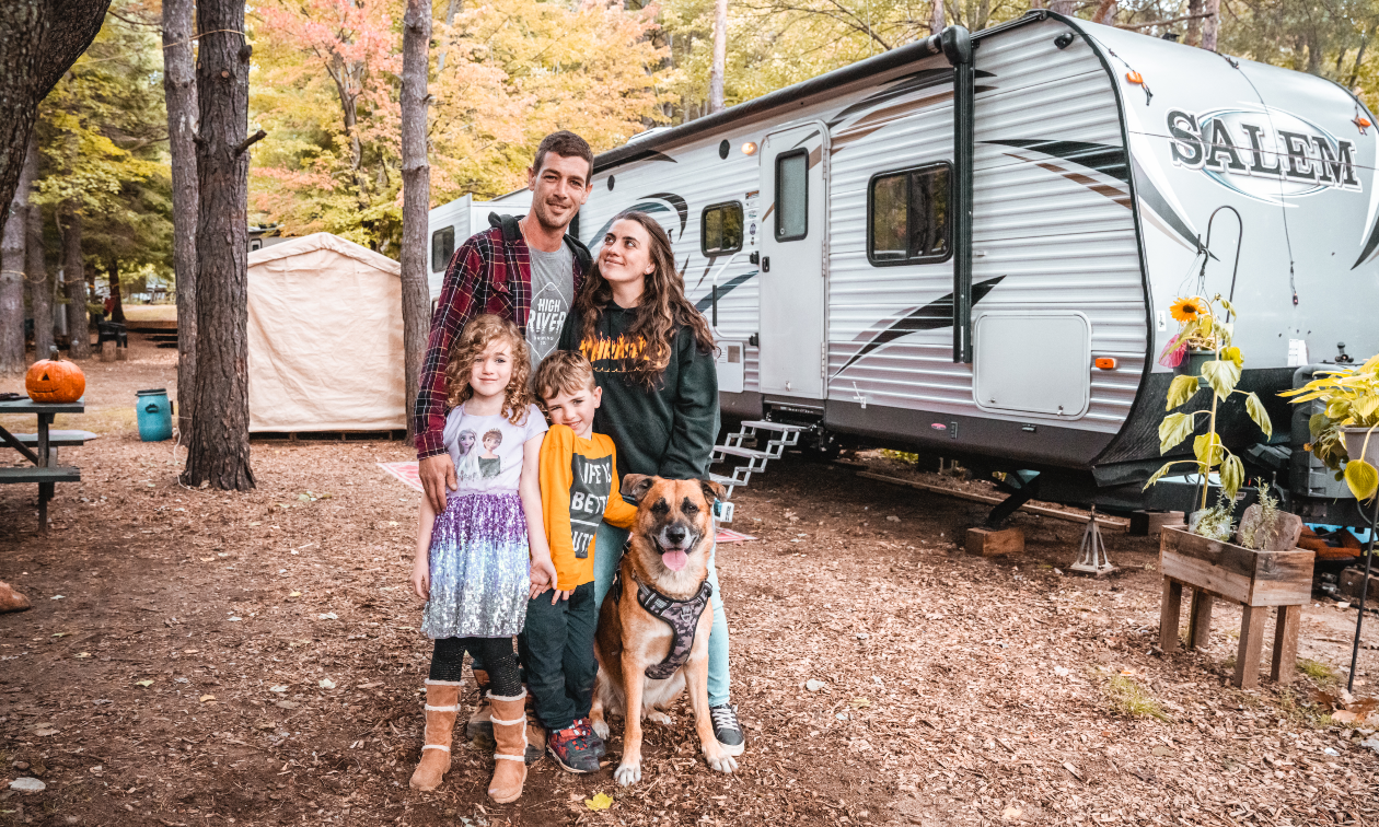 The Perry family standing in front of their RV during fall season