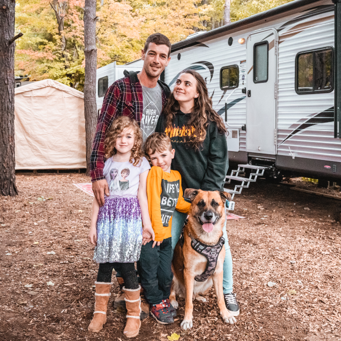The Perry family standing in front of their RV during fall season