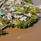 aerial view of the edge of a river and heritage park along the shore