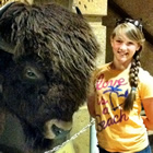 girl standing beside a stuffed buffalo