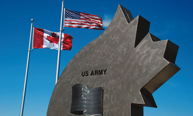 monument along with two flags, for USA and Canada