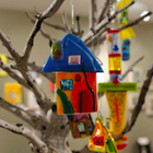 stained glass houses hanging from tree branches