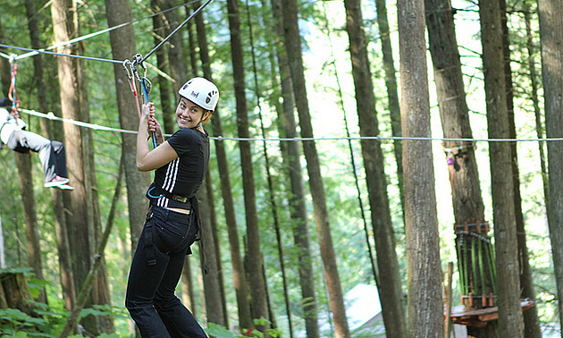 Woman swinging through the trees near Revelstoke