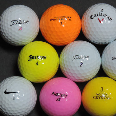 A selection of 9 golf balls of different colours, makes and sizes.