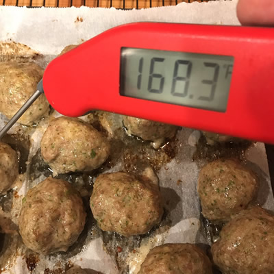 Dish of meatballs with meat thermometer.
