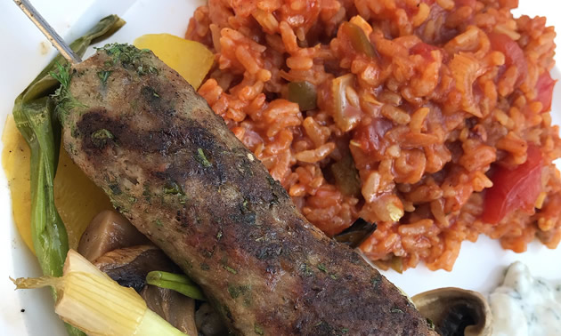 Plate with grilled sausage, vegetables and tomato rice. 
