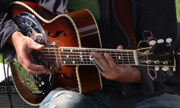 Man playing guitar at Harrison Mills