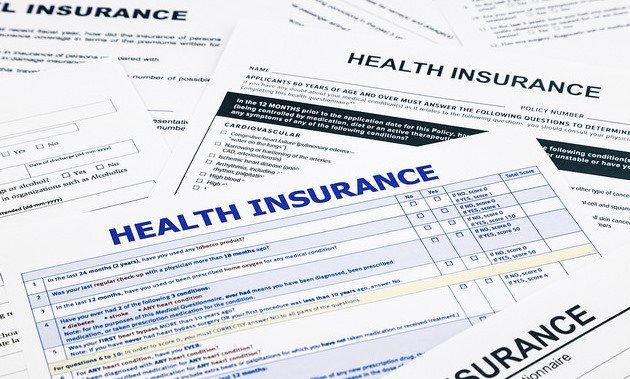 Numerous health insurance policies laying on a table.