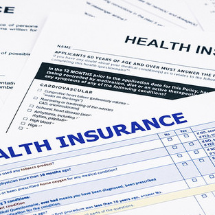 Numerous health insurance policies laying on a table.