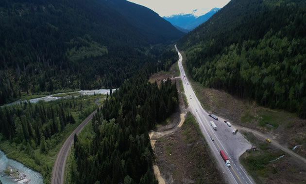 Aerial view of highway through mountains. 