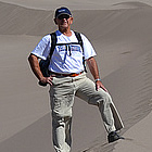 man standing by the sand dunes