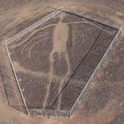 Primitive male figure scraped in desert landscape